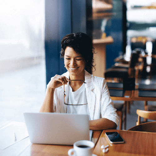 smiling woman on her laptop at a coffee shop