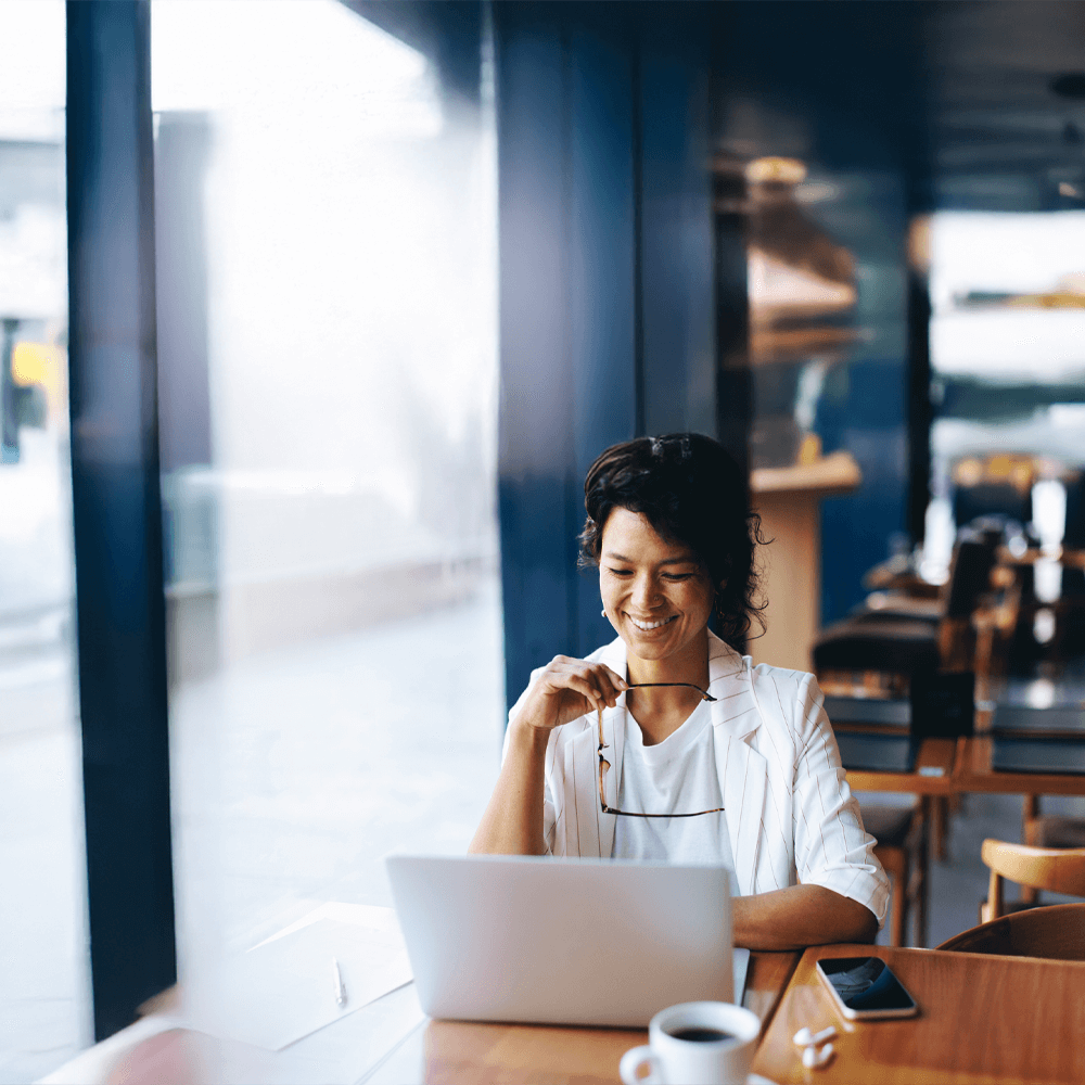 smiling woman on her laptop at a coffe shop