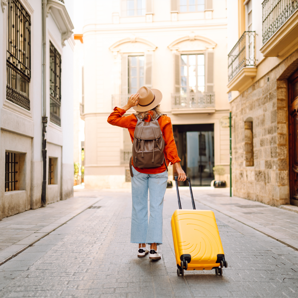 woman carrying a backback and luggage on vacation in europe