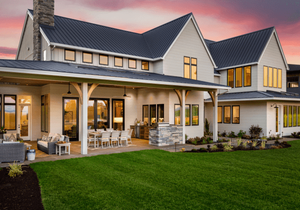 luxury home at sunset with large covered patio with outdoor kitchen and barbecue