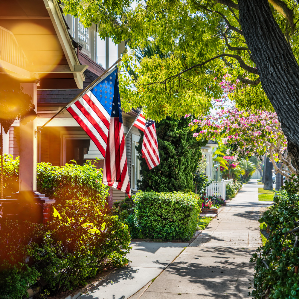 Houses with American flags in a beautiful neighborhood on a sunny day