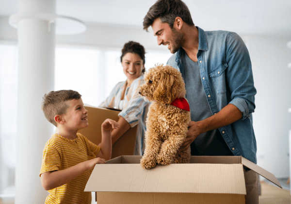 happy family and dog packing moving boxes