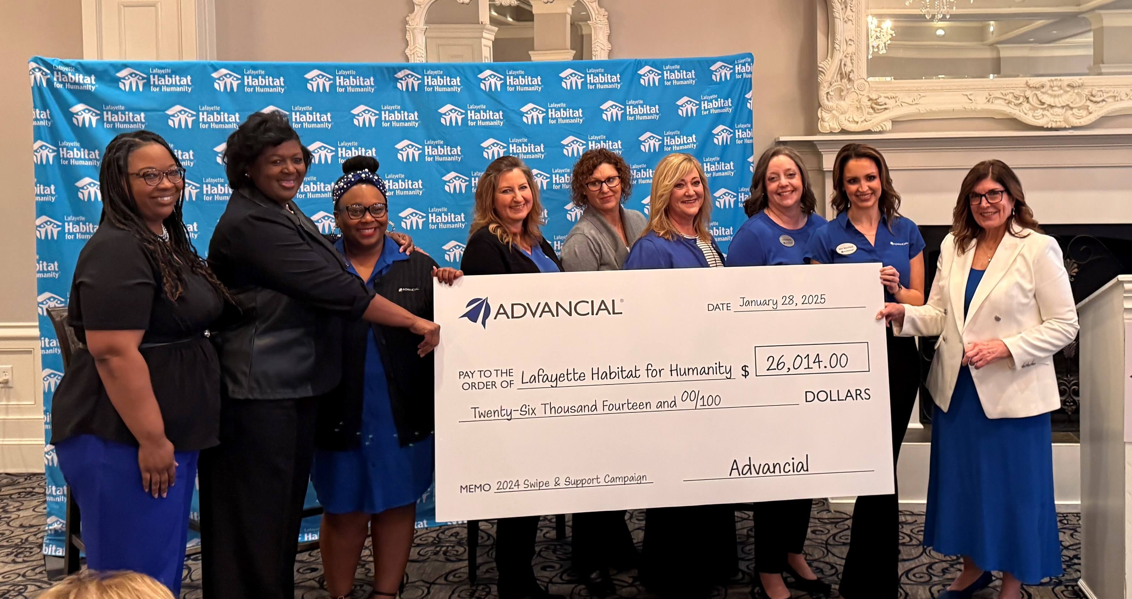 advancial employees presenting a giant check saying advancial members have raised $26,014 for lafayette habitat for humanity