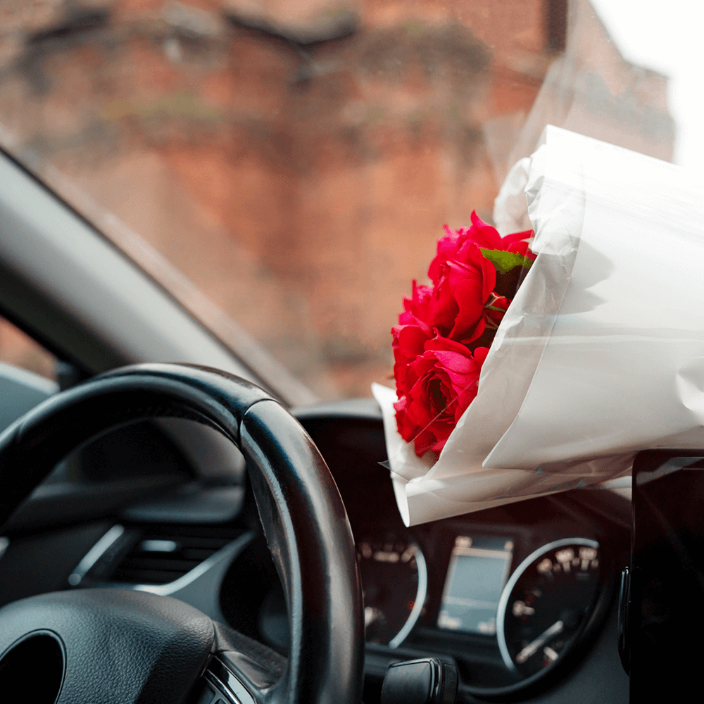 bouquet of red roses on the dashboard of a car