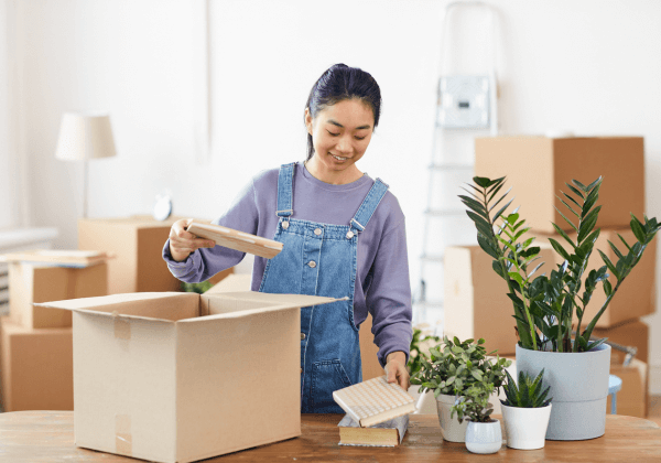 happpy diverse couple unpacking boxes in their living room