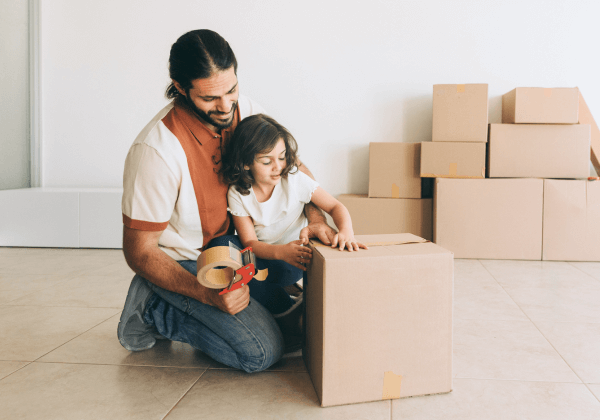 happpy father and daughter packing boxes in their living room